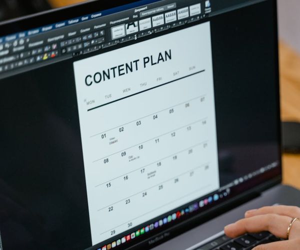 Calendar on a desk next to a laptop showing a scheduled workout.